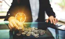 Vom Marktverständnis zur Handlungskompetenz: Energiehandel heute Business Frau mit Glühbirne und Münzen